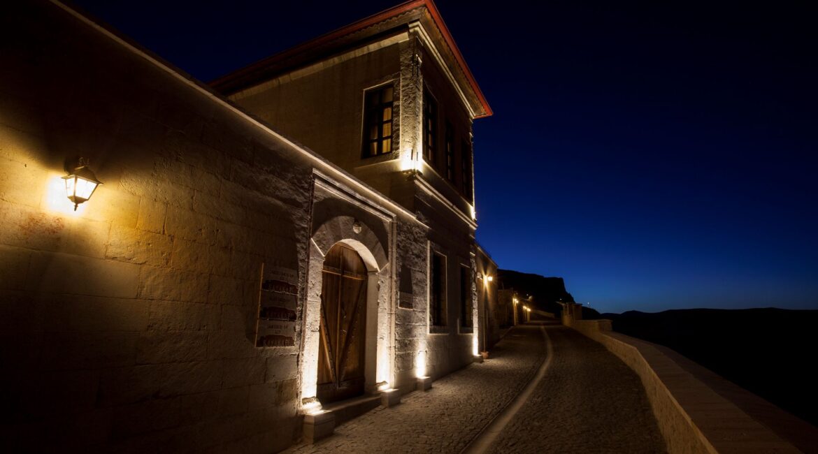 Historic stone buildings illuminated at night at Kayakapı Premium Caves, Ürgüp