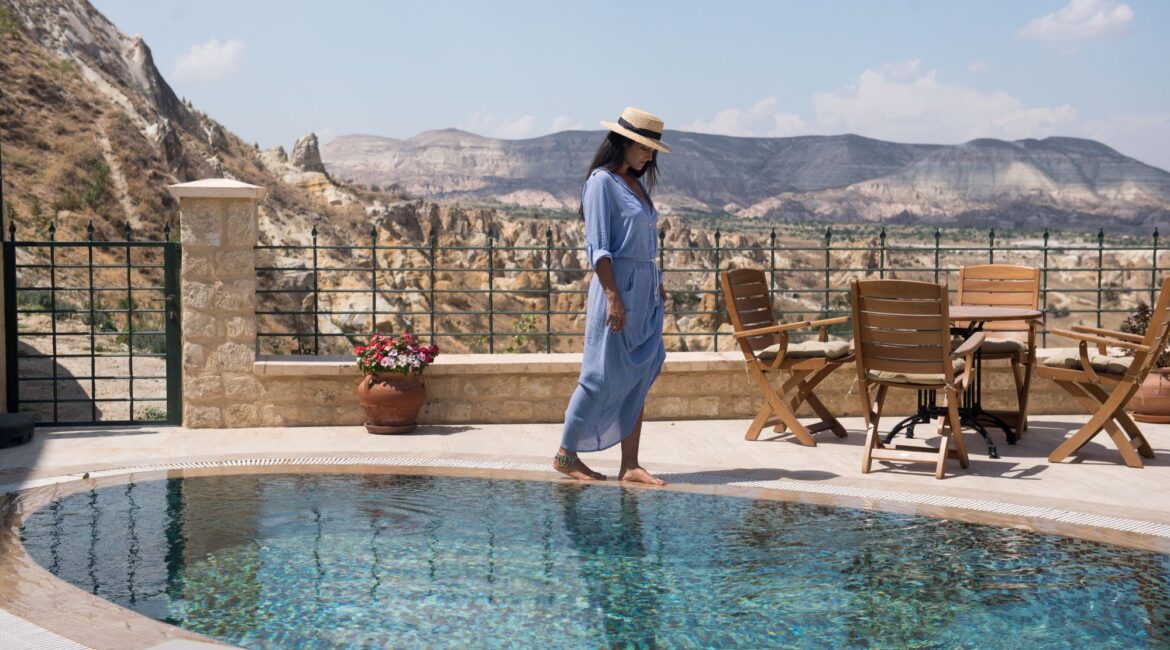 Guest relaxing beside the infinity pool overlooking Cappadocia at Kayakapı Premium Caves