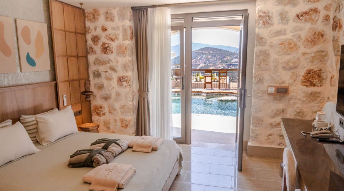 Contemporary interior of Swim Up Room 12 Avelia at Casa Pery Hotel, Kalkan featuring natural stone walls, and the swimming pool just footsteps away.