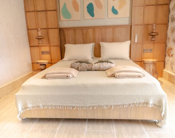 Elegant bedroom in Swim Up Room 12 Avelia at Casa Pery Hotel, Kalkan with natural stone walls and contemporary décor.