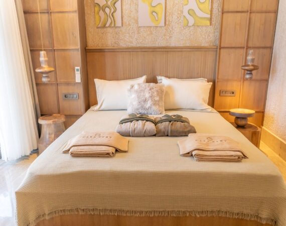 Elegant bedroom in Swim Up Room 13 Elara at Casa Pery Hotel in Kalkan with contemporary décor and bespoke wooden headboard.
