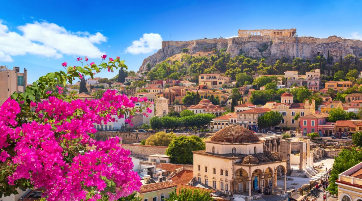 Colourful bougainvillea with views across Monastiraki Square to the Acropolis, Athens, Greece.