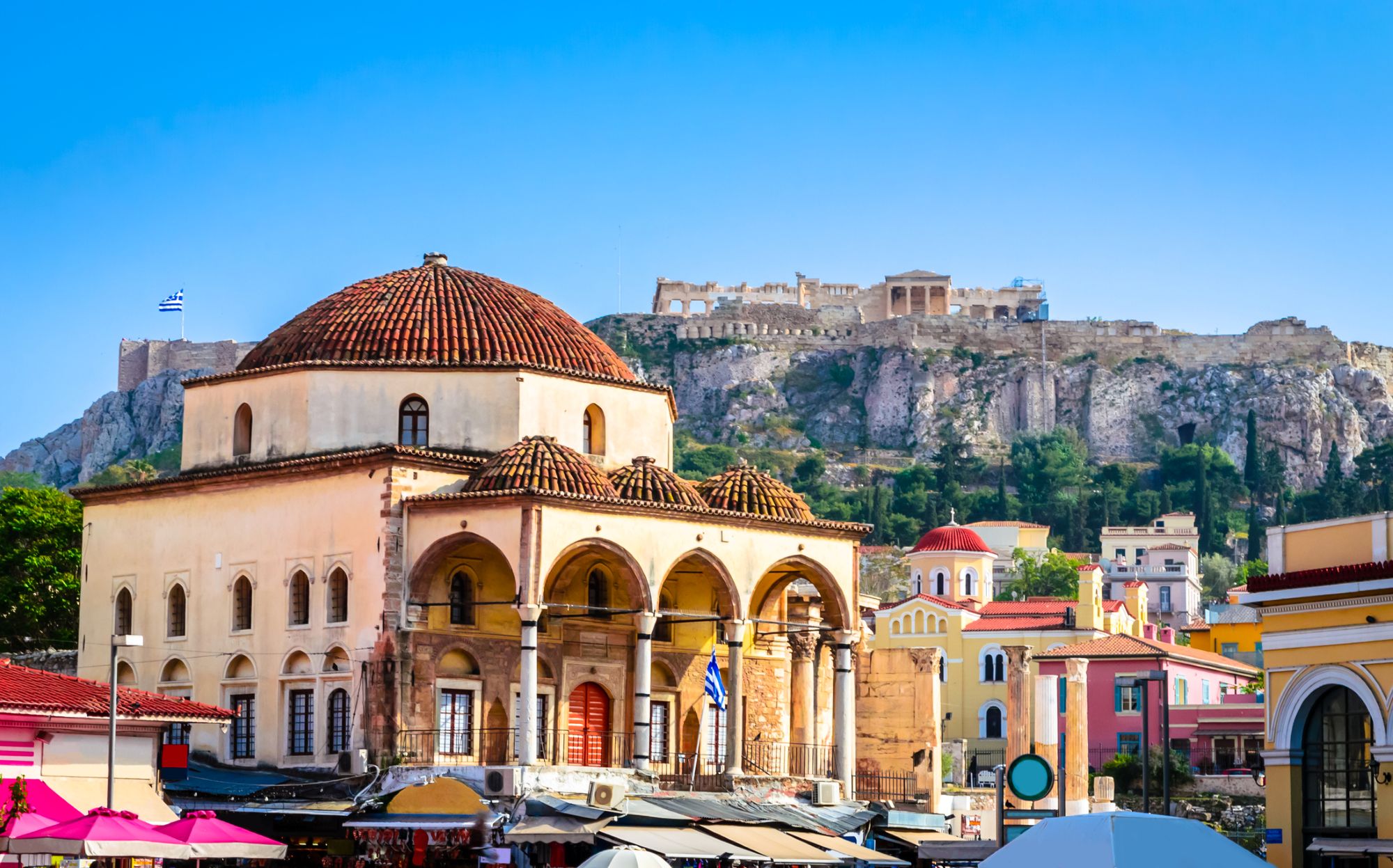 The Tzistarakis Mosque in Monastiraki Square with the Acropolis rising above Athens, Greece.