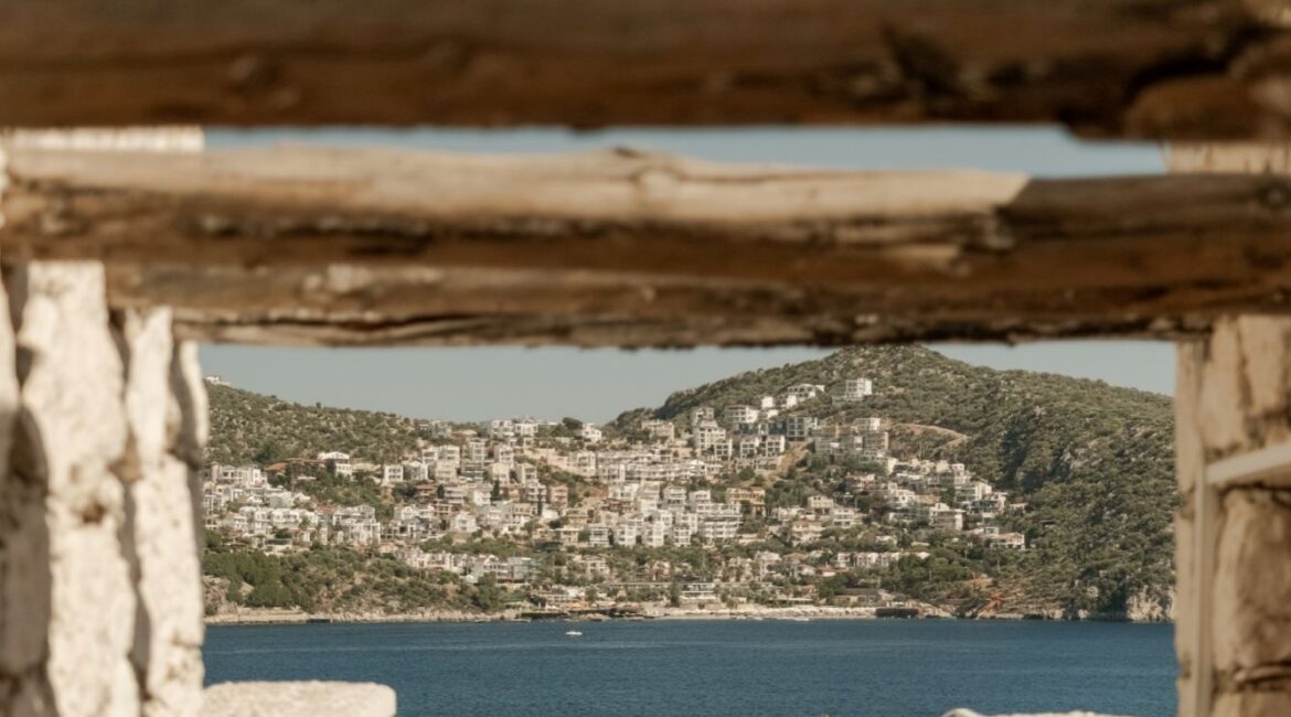Sea view framed by a traditional stone pergola at Likya Gardens, a boutique hotel in Kalkan on Turkey's Mediterranean coast.