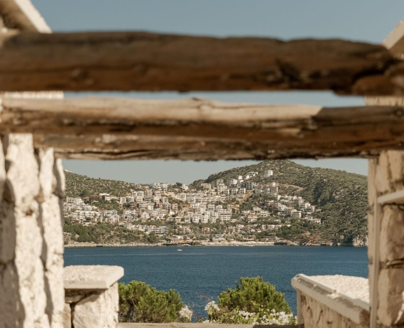 Sea view framed by a traditional stone pergola at Likya Gardens, a boutique hotel in Kalkan on Turkey's Mediterranean coast.