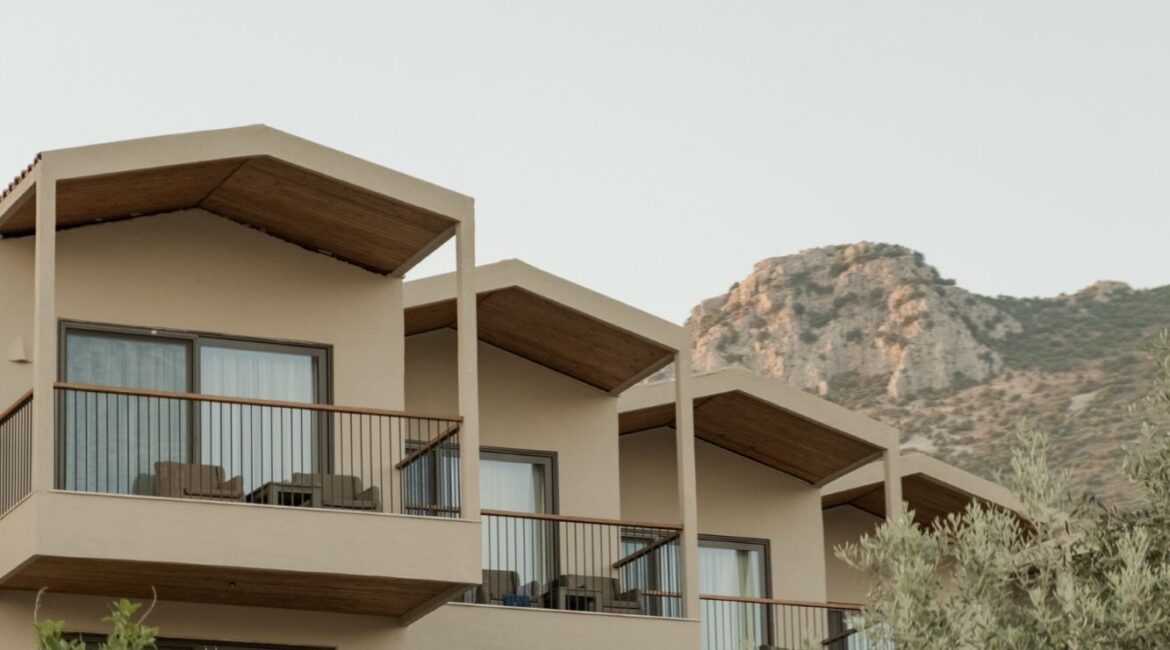 Exterior of Asfiya Sea View boutique hotel surrounded by Mediterranean gardens in Kalkan, Turkey.